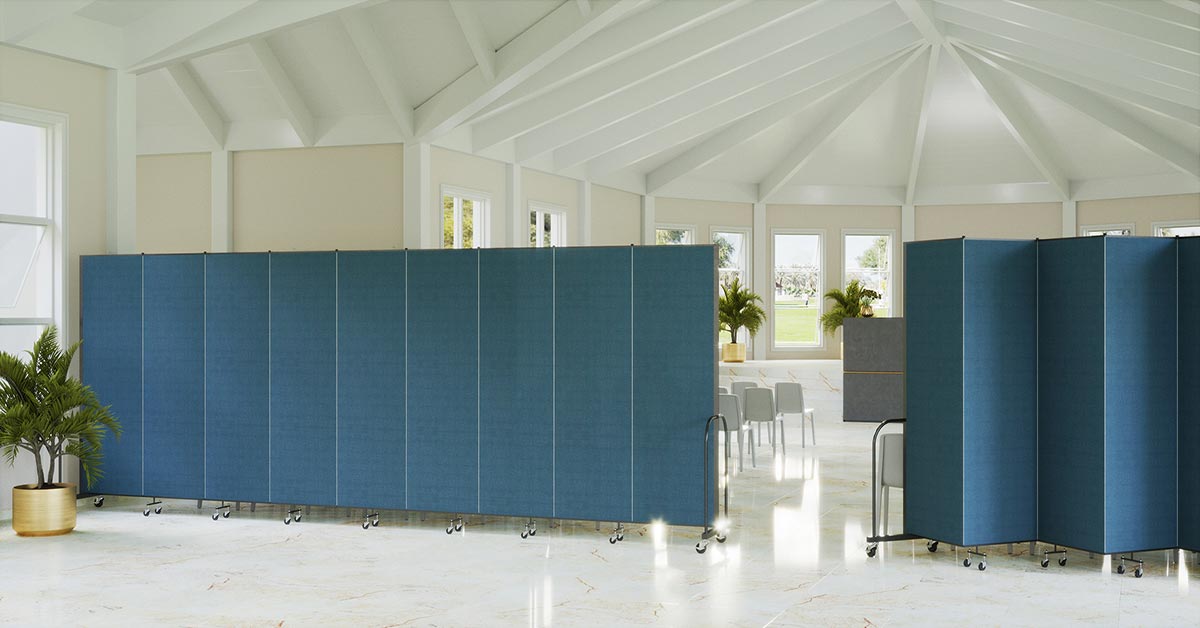 One straight blue room divider and one kinked blue room divider connecting to obscure white chairs in a church.