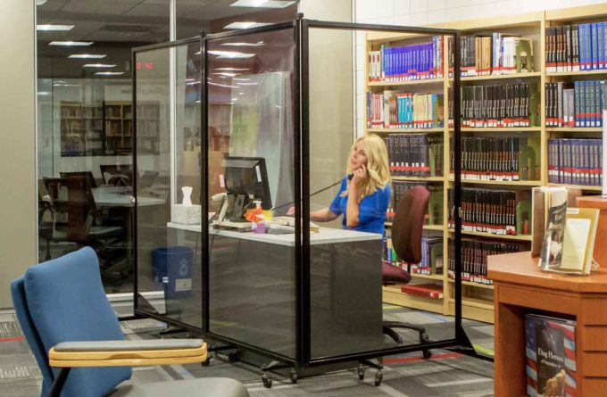 Clear Divider in front of an educator at her desk