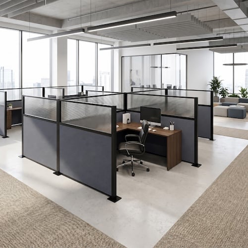 Modern office with modular workstation partitions creating semi-private cubicles in an open workspace.