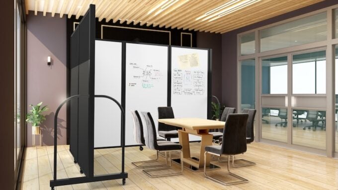 Meeting area with a mobile whiteboard room divider, conference table, and chairs in a modern office.