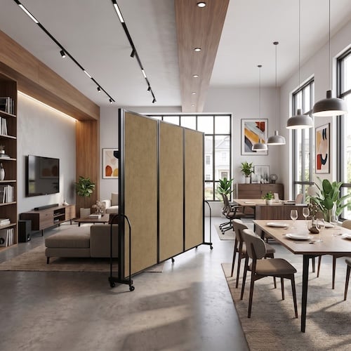Modern open-plan apartment featuring a mobile room divider with beige acoustic panels separating the living room and dining area, accented by warm wood finishes, large windows, and contemporary furnishings.