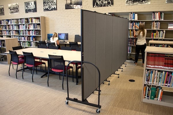 Portable room divider separating study areas in a school library