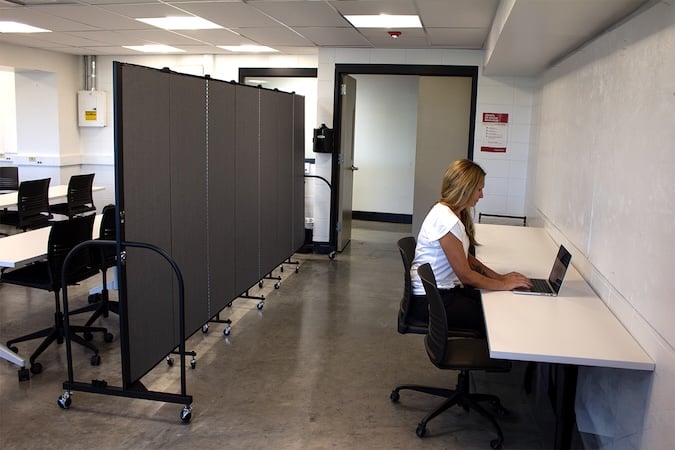 Portable room dividers creating a private workspace in an open classroom.